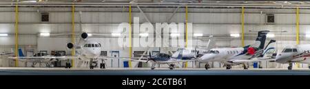 An assortment of private jets parked in an aircraft hangar Stock Photo
