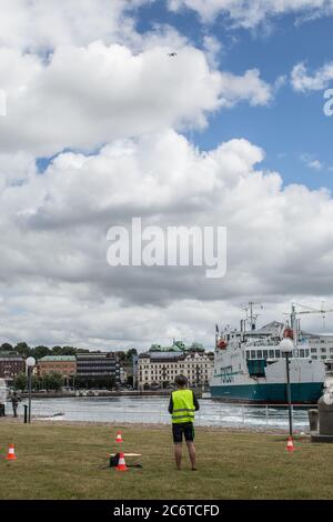 A man flying a drone by the harbor in Helsingborg, Sweden, on a summer day. Stock Photo