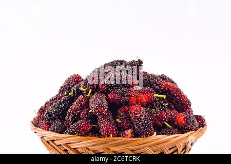 sweet ripe mulberry in  brown basket on white background healthy mulberry fruit food isolated Stock Photo