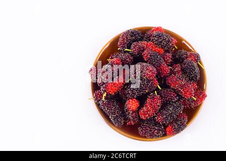 branch of ripe mulberry fruit  in brown bowl on white background healthy mulberry fruit food isolated Stock Photo