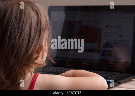 Asian preschooler having online lessons on modern laptop, home education concept Stock Photo