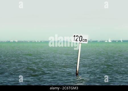 Caution sign in the Lake Balaton, water depth 120 cm. Minimalistic photo of a warning sign for background. Stock Photo