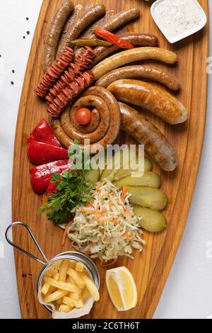 snacks for beer with different sauces, grilled sausages and pickled vegetables, top view Stock Photo