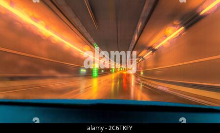 Wet tunnel drive with light colors and reflections. Stock Photo