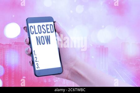 Handwriting text Closed Now. Conceptual photo of a business having ceased trading especially for a short period Modern gadgets with white display scre Stock Photo