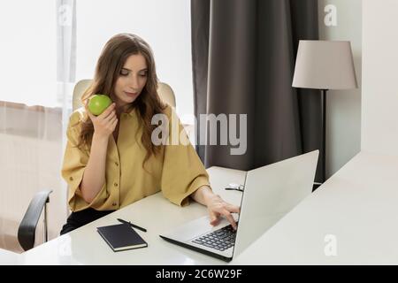 Due to quarantine caused by the covid-19 virus, the woman remained at home. A woman works at a computer without going outside. Stock Photo