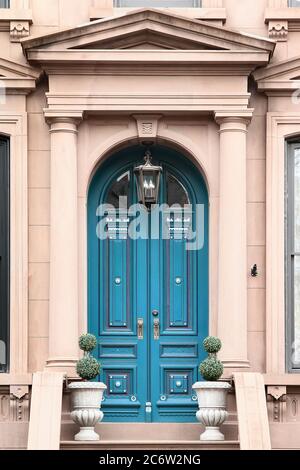 Double azure wooden vintage entry door decorated with fronton and columns. New York. USA. Stock Photo