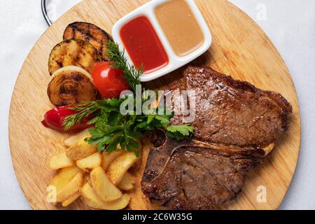 Grilled beef steak with lettuce, pickled cucumber, lettuce and parsley. Concept for healthy nutrition. Flat lay Stock Photo
