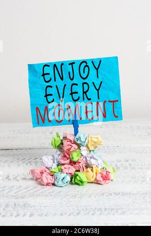 Conceptual hand writing showing Enjoy Every Moment. Concept meaning stay positive thinking for an individualal development Reminder pile colored crump Stock Photo