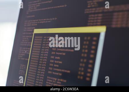 Extreme close up of black and orange programming code on laptop screen, IT and software development concept, copy space Stock Photo
