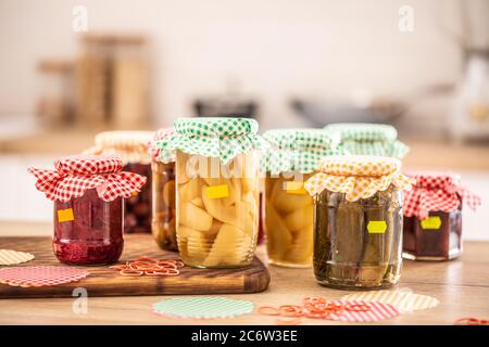 Variety of home made pickles and preserves, checkered tops and yellow labels on jars Stock Photo
