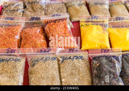Assorted herbs and spices in clear plastic bags on the market Stock Photo