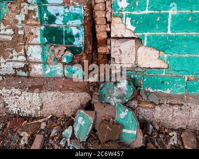 You can see the severe damage to the old wall of the house with large pieces of plaster falling nearby Stock Photo