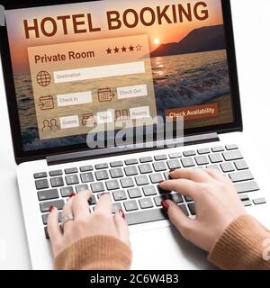 Woman hands using hotel booking website on laptop Stock Photo
