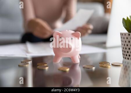 Close up of piggy bank on table with coins Stock Photo