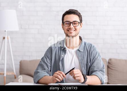 Online conference with team or chatting with followers. Man with glasses looks at webcam Stock Photo