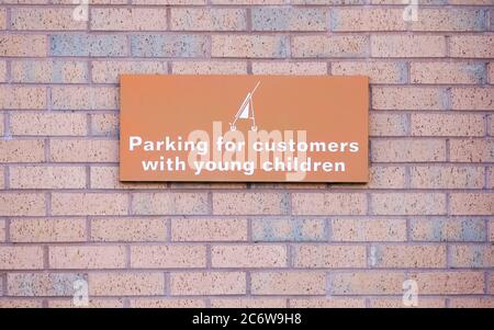 Parent and child parking only sign on large open white wall space in car park for information Stock Photo