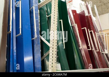 Siding metal multi-colored pallet row set rack ready for construction on hardware industrial store. Stock Photo