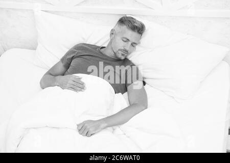 Good Sleep is Reachable Dream. World Sleep Day. Benefits of good and healthy sleep. Breathe Easily, Sleep Well. Handsome man in bed. Sleeping guy at home. Need more rest. Peaceful mature man relaxing. Stock Photo