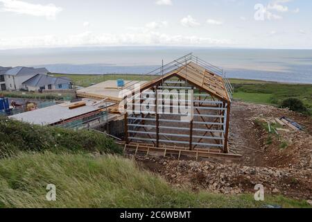 The long awaited village hall under construction in Ogmore by sea with its steel framed shell and new wooden artistic roofing design within the frame. Stock Photo