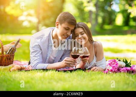 https://l450v.alamy.com/450v/2c6wke9/affectionate-young-couple-lying-on-picnic-blanket-with-glasses-of-red-wine-outside-2c6wke9.jpg