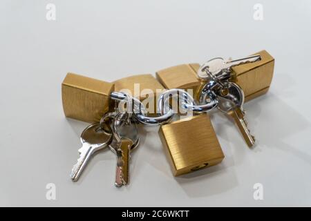 Small bronze locks with steel keys lie on a white background Stock Photo