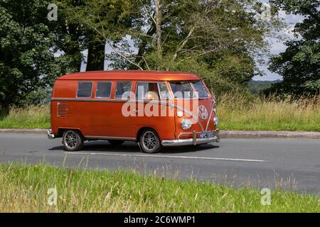 1966 60s sixties red LCV Restored Orange Split-Screen VW Volkswagen Motor Caravan; Vehicular traffic moving vehicles, caddy, Transporter, camper vans, kombi, combi, campervan van, motorhome, conversion, Vee Dub, conversions, window van microbus, bus, campers, motorhomes cars driving vehicle on UK roads, motors, motoring on the M6 motorway highway network. Stock Photo