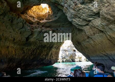 Albufeira, Portugal - July 11, 2020: A group of tourist in a boat visiting the caves of Benagil Stock Photo