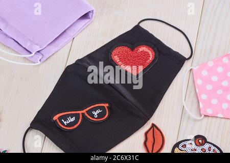 Black fabric mask with red embroidered patches Stock Photo