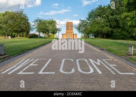 Guildford Cathedral viewed from the bottom of the hill with a Welcome message on the road, Surrey, UK Stock Photo