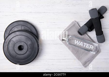 https://l450v.alamy.com/450v/2c6x7ty/fitness-concept-bottle-of-water-dumbbells-and-weight-plates-on-wooden-background-top-view-2c6x7ty.jpg