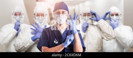 Team of Female and Male Doctors or Nurses Wearing Personal Protective Equipment In Hospital Hallway Stock Photo