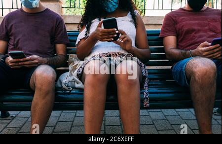 three people with mask in bank using mobile phone, social distance concept with face mask Stock Photo