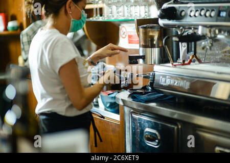 Young adult caucasian female barista wearing surgical face mask Stock Photo