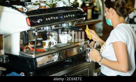 Young adult caucasian female barista wearing surgical face mask Stock Photo