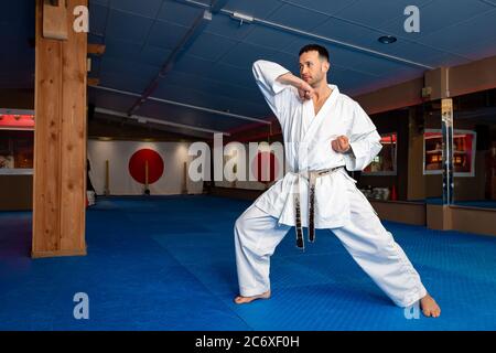Karate man stand your ground on tatami doing 'Empi Waza' Stock Photo