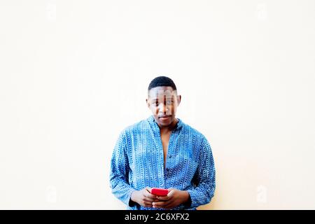 young african man using his red smartphone Stock Photo