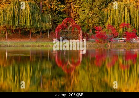 Evening in the autumn city park. Trees are reflected in the pond. Ukraine, Kyiv. 'Feofania' park. Stock Photo