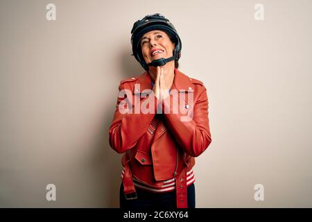 Middle age motorcyclist woman wearing motorcycle helmet and jacket over white background begging and praying with hands together with hope expression Stock Photo