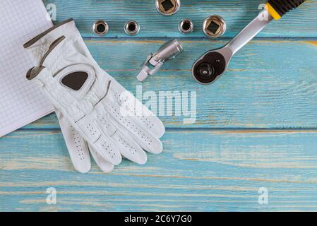 Car repair auto mechanic for combination wrenches working gloves in spanner automobile on a wooden blue background Stock Photo
