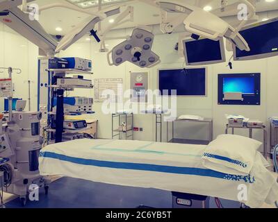 Operating theater  (room) in a modern hospital interior shot with bed in the middle , anesthesiology and lightening equipment. no people Stock Photo