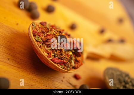 Different ground spices in a wooden spoon on a wooden background. Close up Stock Photo