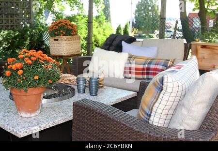 Outdoor seating arrangement around a gas fire pit table in the fall on a patio Stock Photo