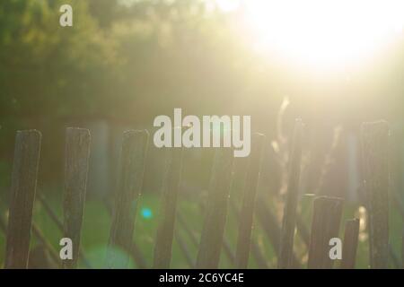 the old wooden fence from behind shines Stock Photo