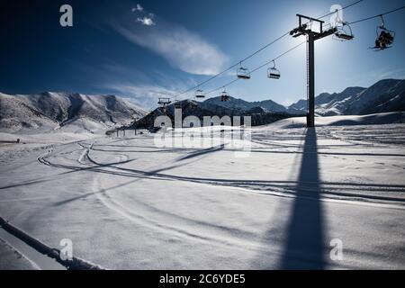 Tourists and sportsmen explore the pistes of Chunkurchak Ski Base in the Chuy Oblast of Kyrgyzstan near Bishkek. Stock Photo