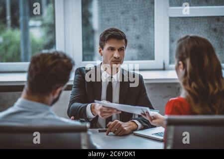 Couple signing wedding contract while sitting in lawyers office Stock Photo