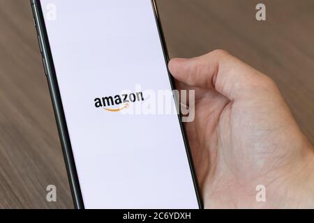 Person using cellphone with the Amazon, Inc. logo on-screen. Stock Photo