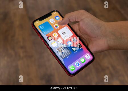 Person seen using an iPhone, running iOS 14. Apples 2020 release of their phones operating software. Stock Photo