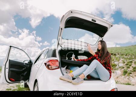 Woman using powerbank smartphone charging and travel by car Stock Photo
