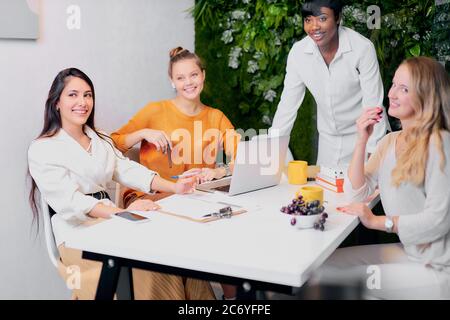 Smiling black manager coach speaking at caucasian corporate meeting, african coach, leader talking to office workers at training teaching employees ex Stock Photo